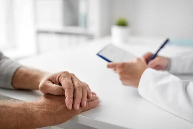A doctor is talking to a patient in a medical room.