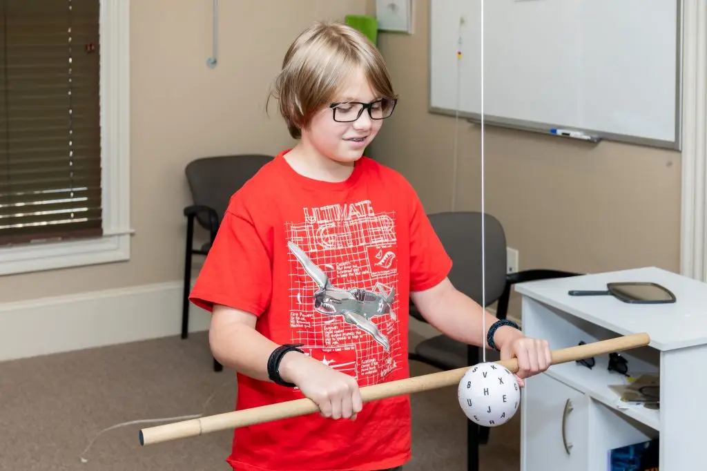 A young boy is playing with a toy in a classroom.