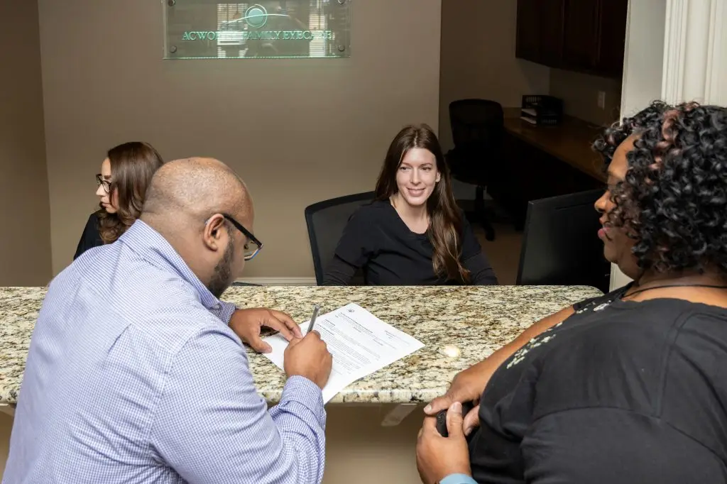 A group of people sitting at a table in an office setting