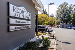 Exterior of Redwood Eye Center with doctors names and cars parked in the lot