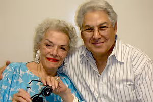 Elderly man and woman with glasses smiling for the camera