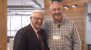 two men standing together smiling for a picture