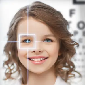 A girl with blue eyes and brown curly hair is smiling and has her eyes closed, probably at an eye clinic.