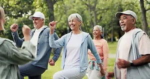 Group of elderly people doing a dance routine in a park