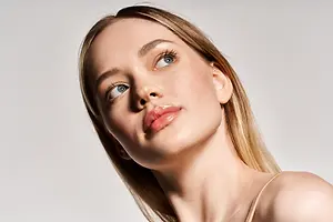 A woman with blonde hair and blue eyes posing for a photograph