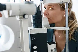 woman with blonde hair getting an eye exam at the doctor's office