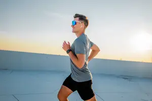 A man is running on a rooftop during sunset.