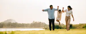 Image of a family walking in the grass near a lake