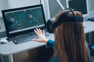A woman with long hair playing a game on a computer using a VR headset.