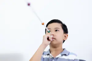 A child uses a toy telescope to look at something in front of them