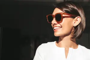 Smiling woman with sunglasses and white blouse