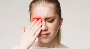 woman touching her eye with her hand