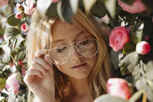 Blonde woman in pink flowers wearing aviator sunglasses