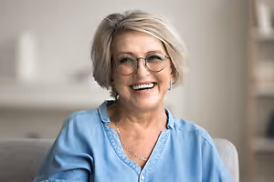Elegant elderly woman sitting on a couch and smiling