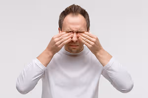 Image of a man rubbing his eyes with both hands