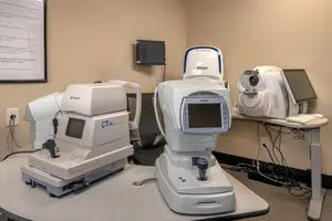 Medical equipment including a CT scanner and other machines on a table in a clinic room.