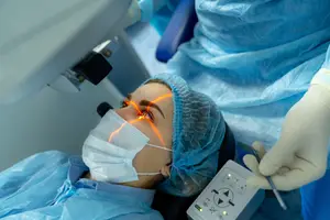 A woman undergoing laser eye surgery in a clinic with medical professionals present