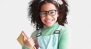 young girl with glasses holding books smiling