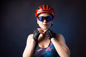A woman wearing a red helmet and sunglasses is posing for a picture