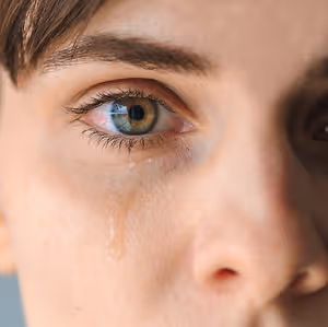 A close up of a woman's face with tears in her eyes