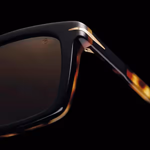 Close up of sunglasses with a black frame and brown lenses