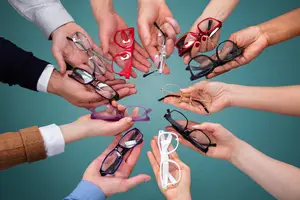 Many people are holding glasses in their hands in a circle.