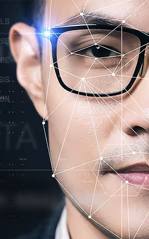 Close-up of a man's face with a light focused on his glasses, overlaid with a network of lines and dots for a futuristic effect