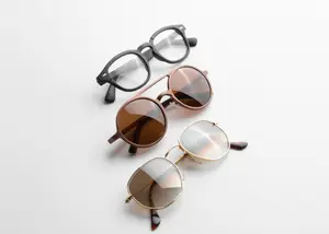 Three pairs of glasses with different lens colors and frames are displayed on a white background.