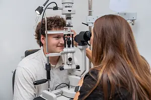 a man getting his eye examined by a female doctor