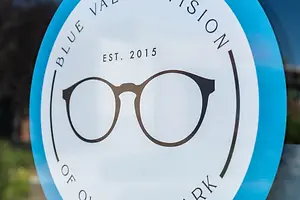 Blue Valley Vision of Park logo with glasses design and text on a glass surface