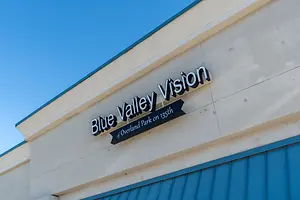 A storefront with a blue awning and a sign reading Blue Valley Vision of Overland Park on 135th