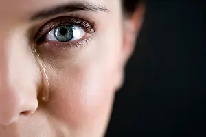 Woman with a tear in her eye looking into the camera