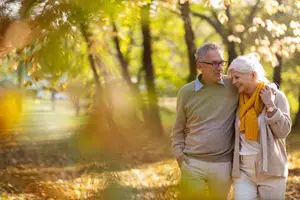 Elderly couple walking in the park with a warm and sunny atmosphere