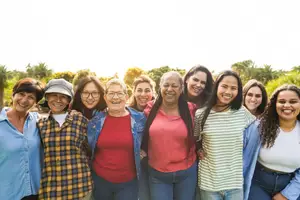 A group of smiling women standing together in a park