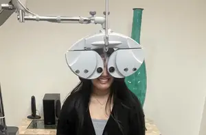 A woman is having an eye test using an autorefractor machine