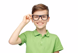 A smiling boy with brown hair wearing glasses and a green polo shirt.