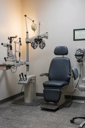 A doctor's office with an ophthalmoscope and an ophthalmologist's chair.