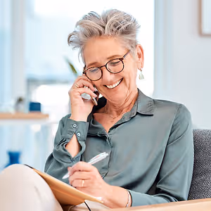 senior woman sitting in chair talking on phone