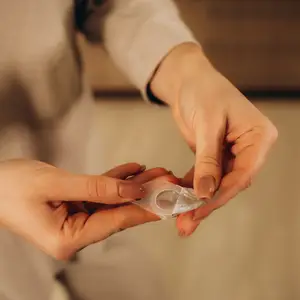 female holding contact lenses on her finger