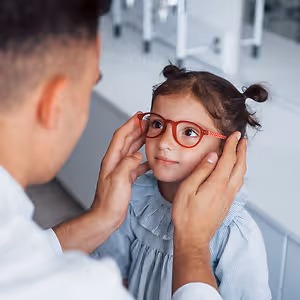 young girl smiling fitting eyeglasses