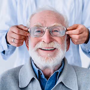 happy old man fitting on eyeglasses