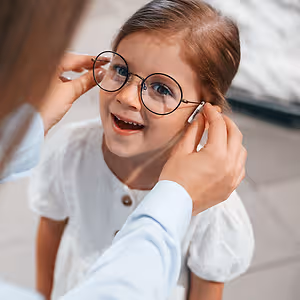 wearing new eyewear. woman and girl is in the glasses store