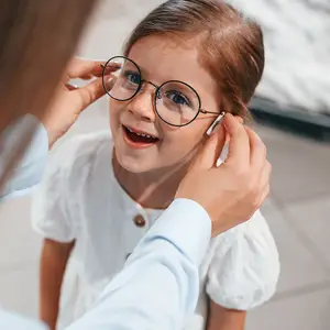wearing new eyewear. girl is in the glasses store