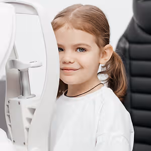 happy young girl during pediatric eye exam at Glimpse Eye Care - The Woodlands