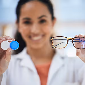doctor holding contacts and glasses