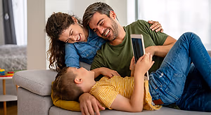 Happy family using a tablet on a couch