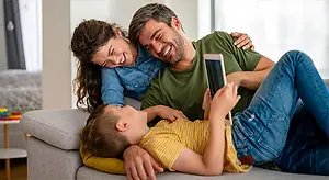 Happy family using a tablet on a couch