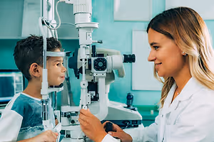 A young boy having his eyes examined by an optometrist
