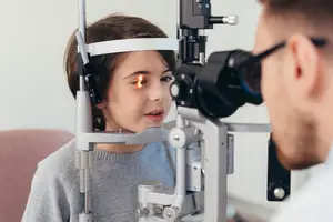 A child is having an eye exam with an eye doctor in a clinic.