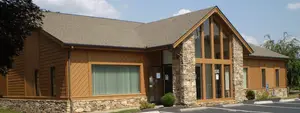 a gray shingled building with brown accents and glass windows